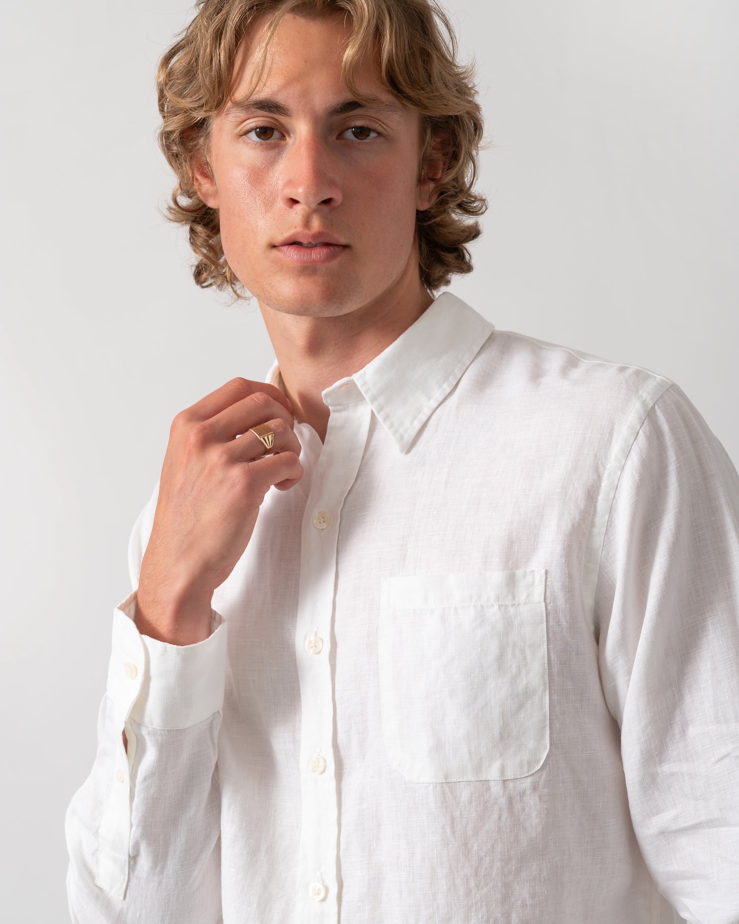 close up shot of a model wearing a Colorful Standard Mens Long Sleeve Linen Shirt in Optical White