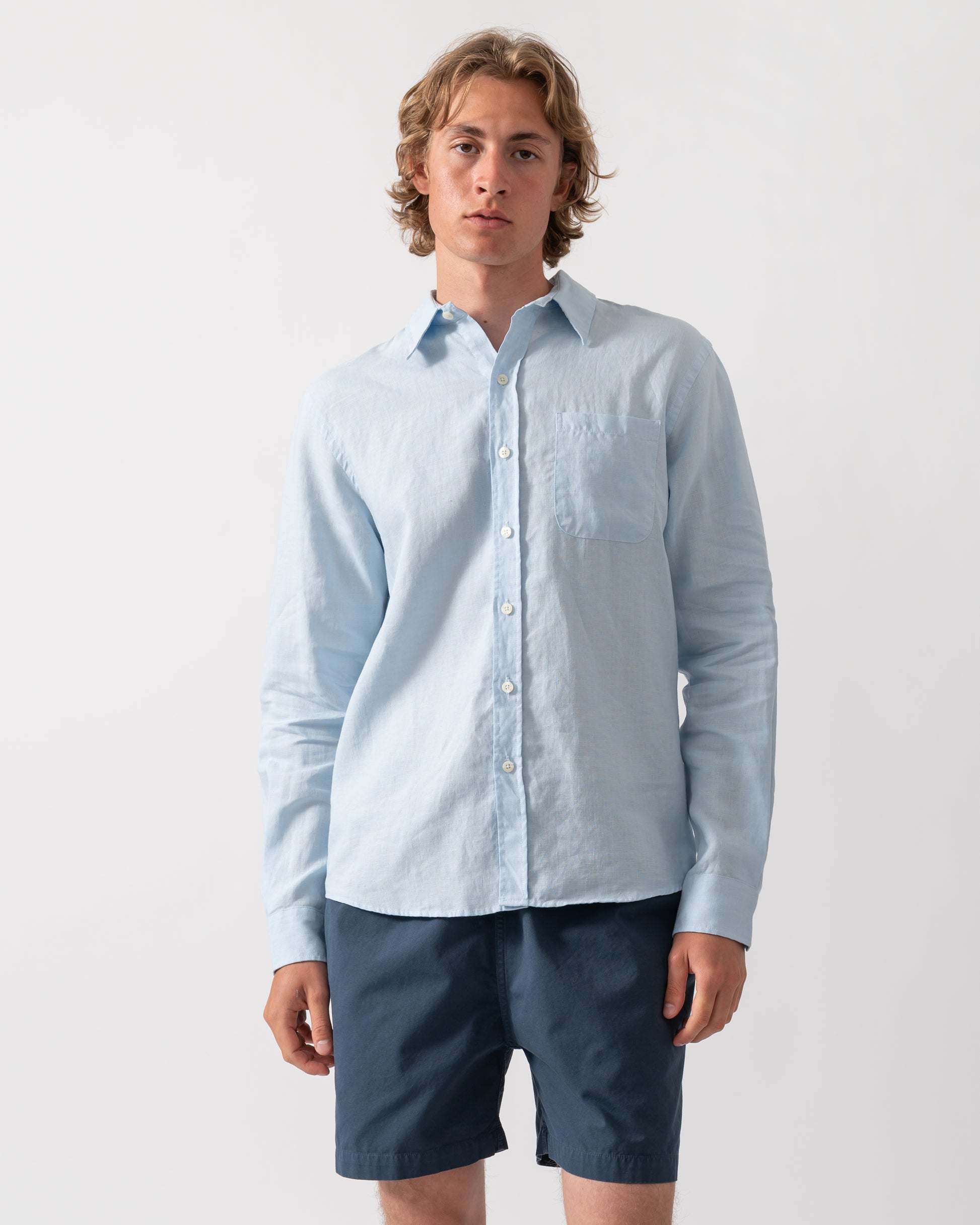 Model wearing a Colorful Standard Mens Long Sleeve Linen Shirt in Polar Blue