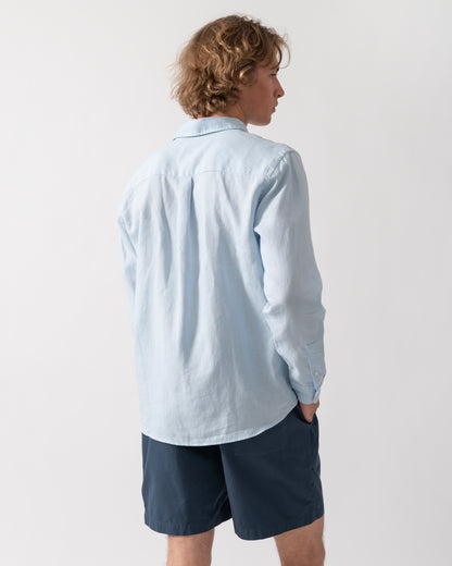back shot of a Model wearing a Colorful Standard Mens Long Sleeve Linen Shirt in Polar Blue