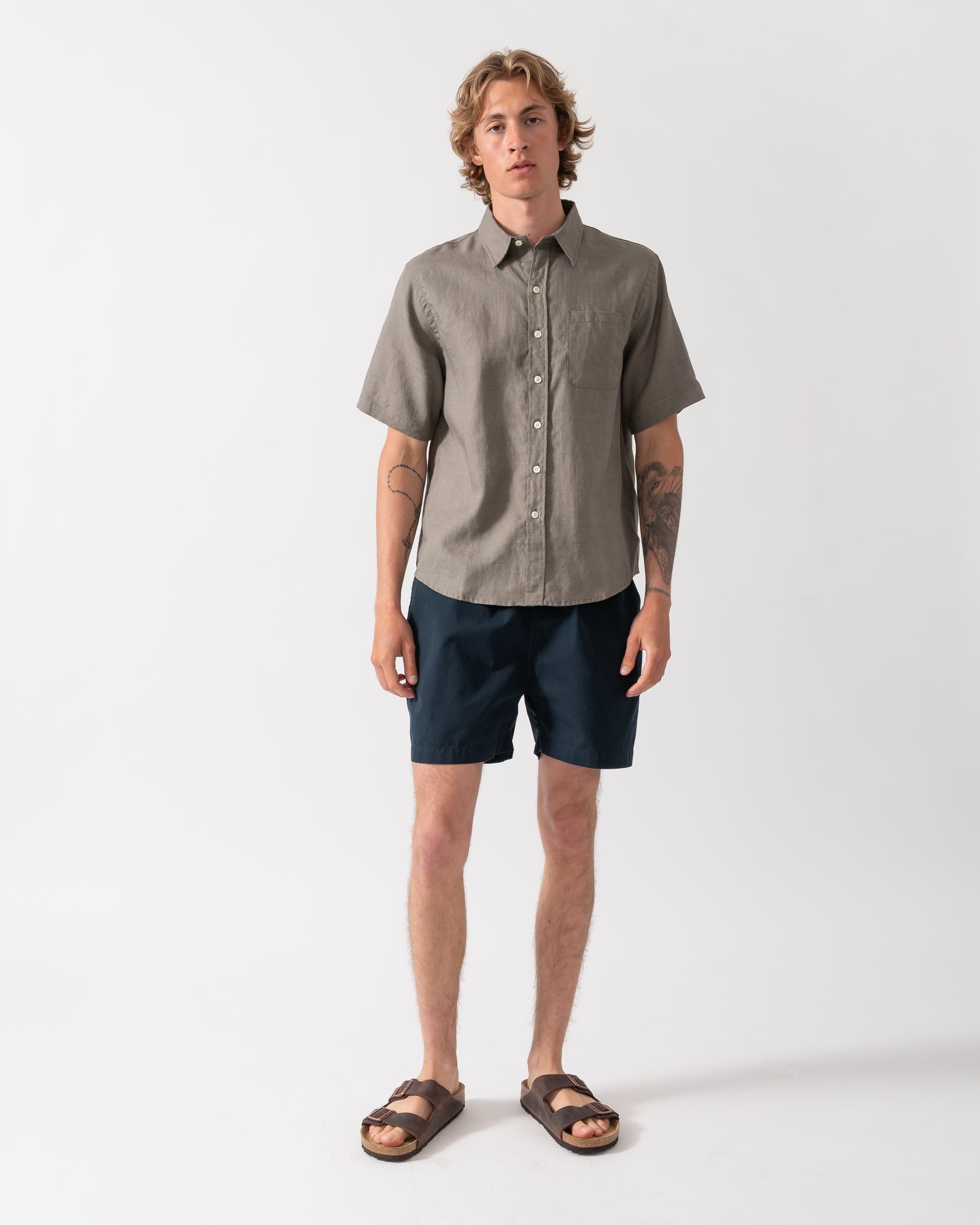 full length shot of a model wearnig a Colorful Standard Mens Short Sleeve Linen Shirt in Dusty Olive