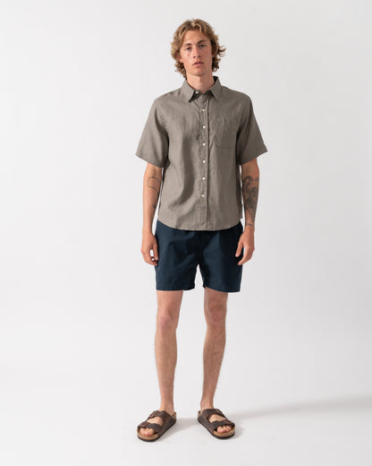 full length shot of a model wearnig a Colorful Standard Mens Short Sleeve Linen Shirt in Dusty Olive