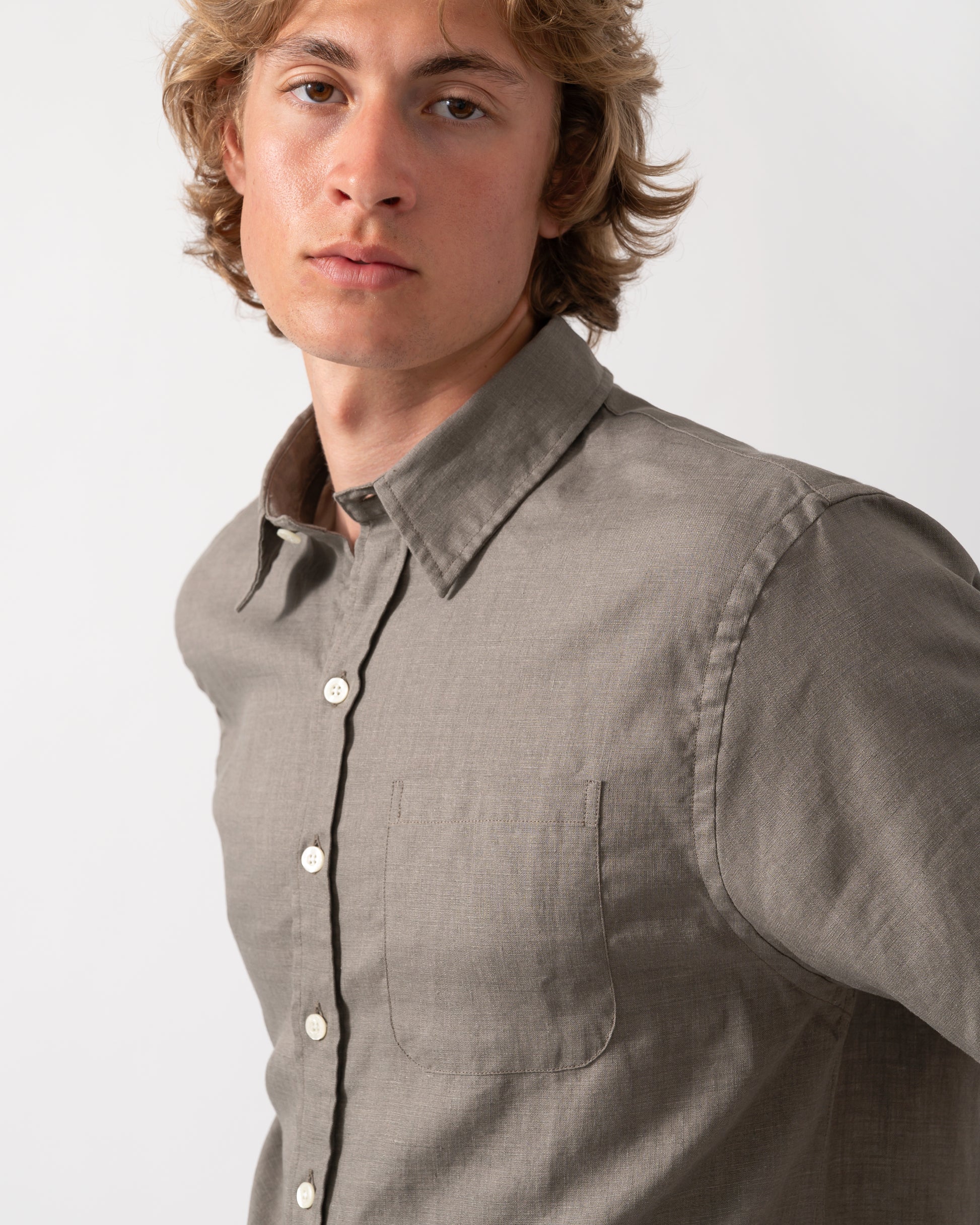 close up shot of a model wearnig a Colorful Standard Mens Short Sleeve Linen Shirt in Dusty Olive