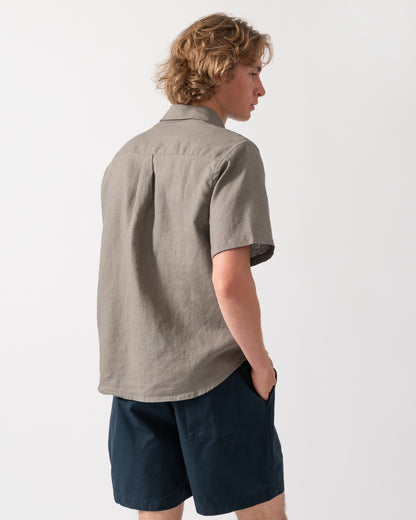 back shot of a model wearnig a Colorful Standard Mens Short Sleeve Linen Shirt in Dusty Olive