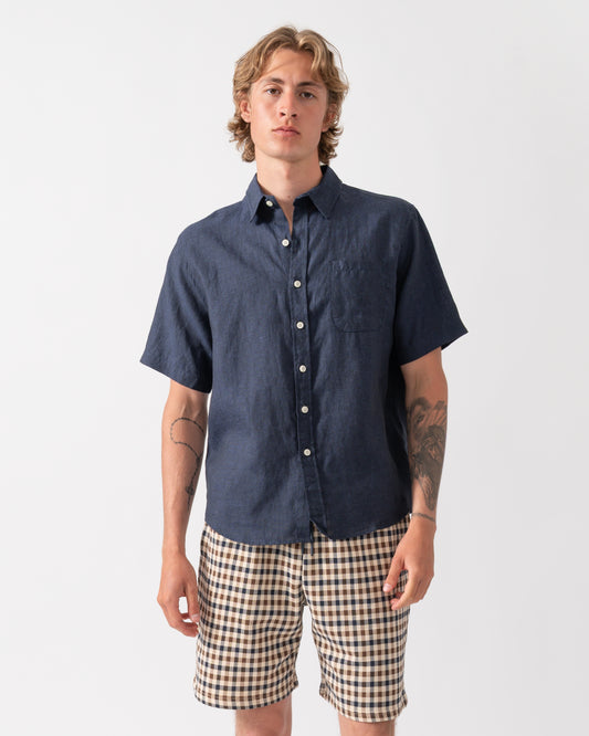 model wearing a Colorful Standard Mens Short Sleeve Linen Shirt in Navy Blue