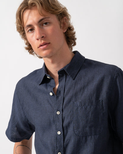close up shot of a model wearing a Colorful Standard Mens Short Sleeve Linen Shirt in Navy Blue