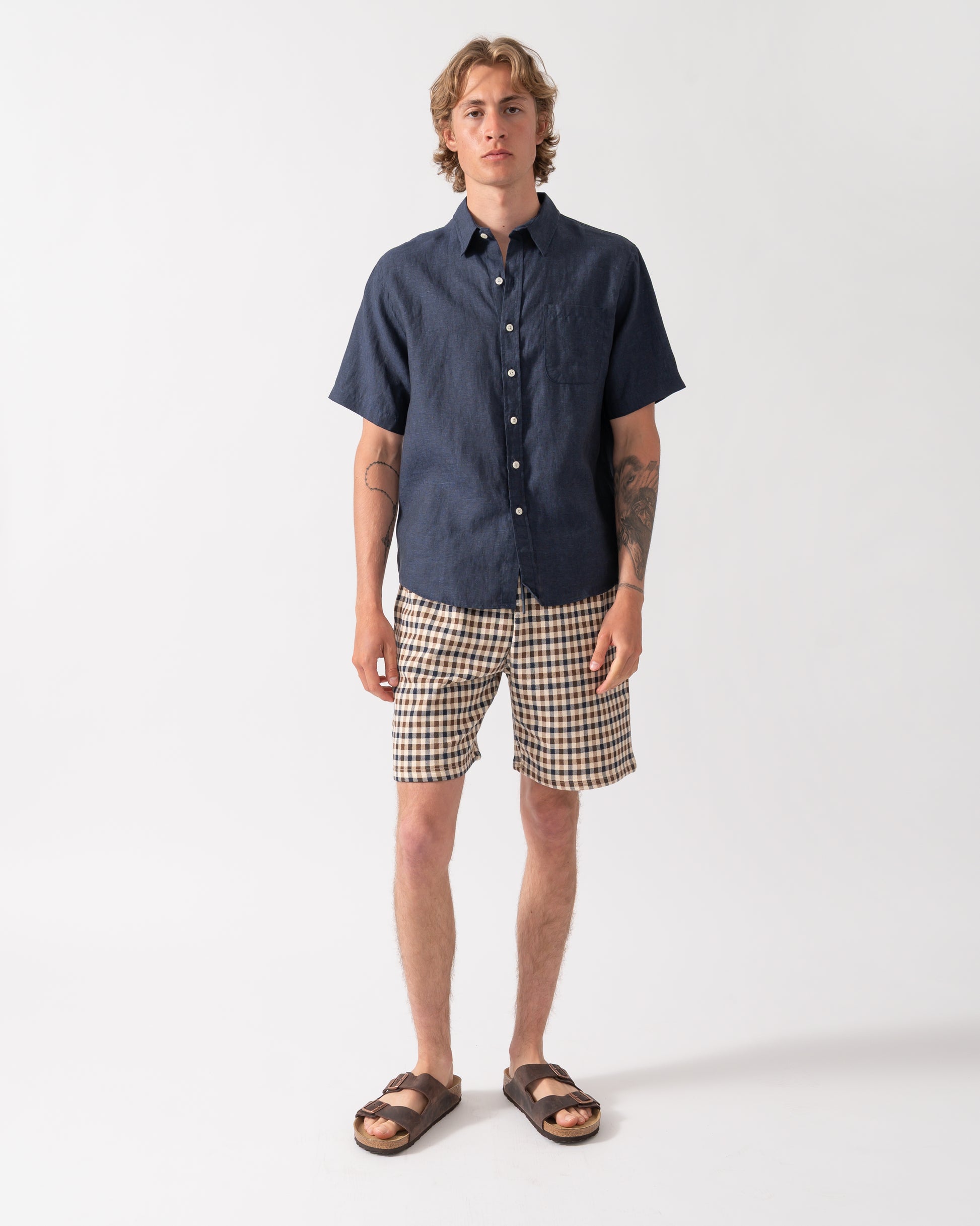 full length shot of a model wearing a Colorful Standard Mens Short Sleeve Linen Shirt in Navy Blue