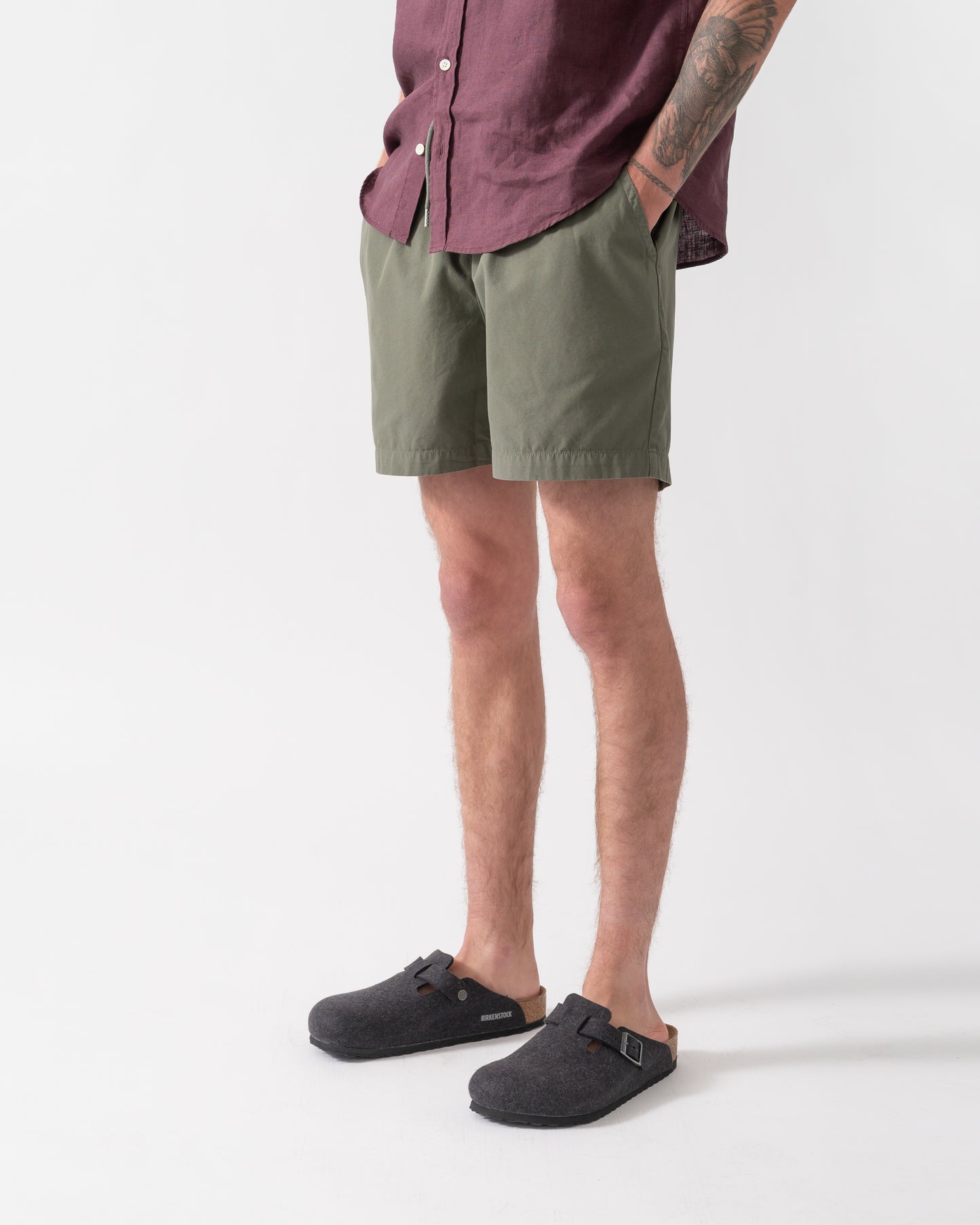 side shot of model wearing Colorful Standard Organic Twill Shorts in Dusty Olive