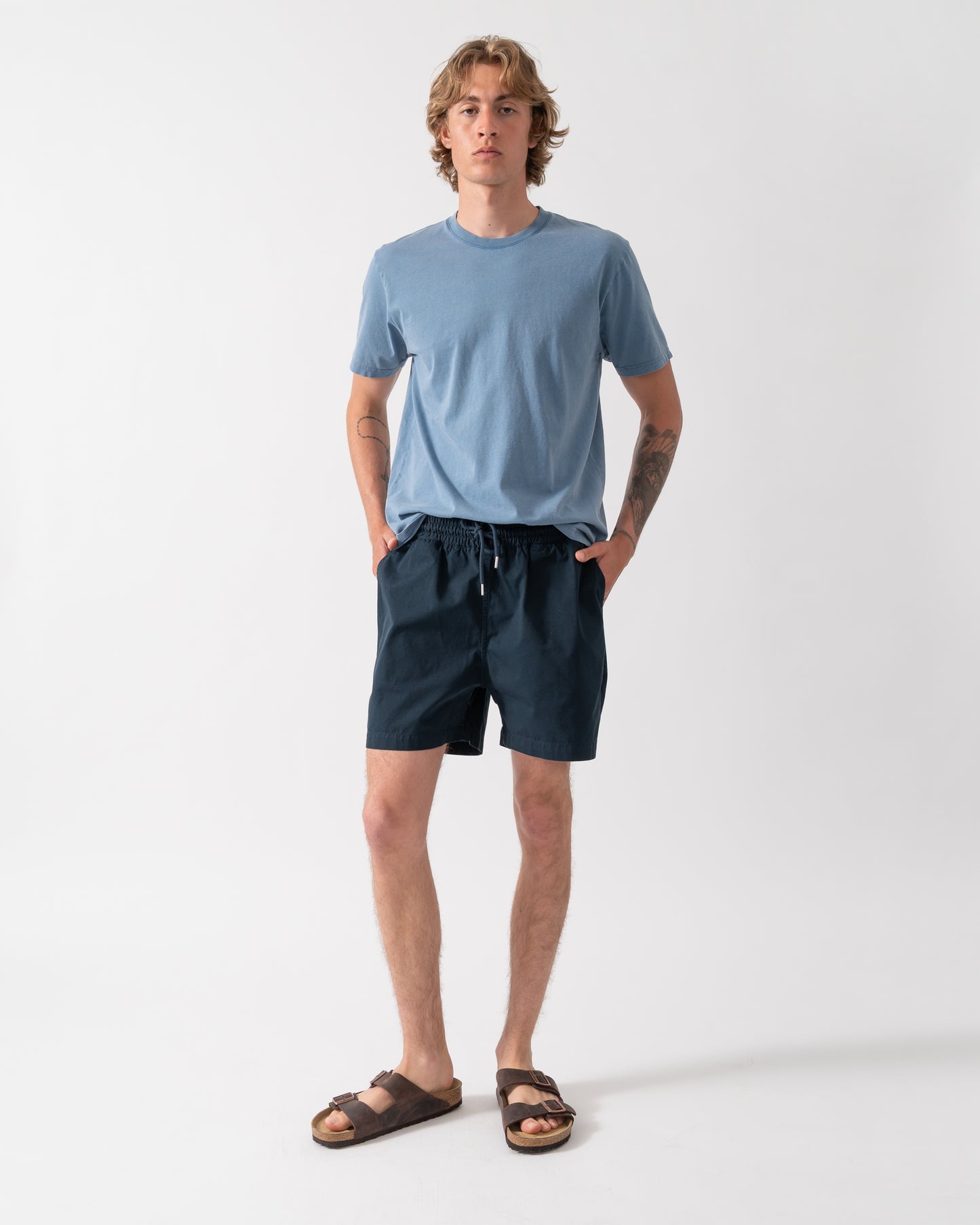 full length shot of a model wearing Colorful Standard Organic Twill Shorts in Navy Blue