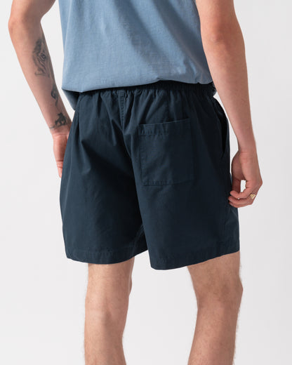 back of a model wearing Colorful Standard Organic Twill Shorts in Navy Blue