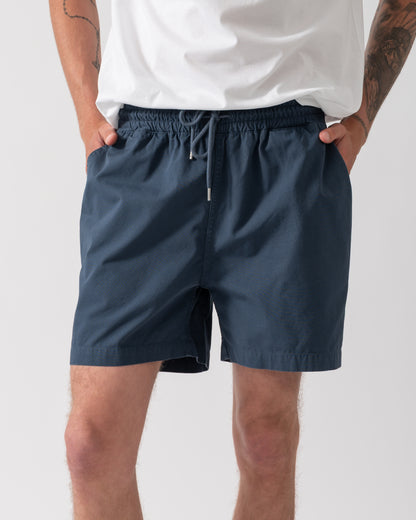 model wearing Colorful Standard Organic Twill Shorts in Petrol Blue