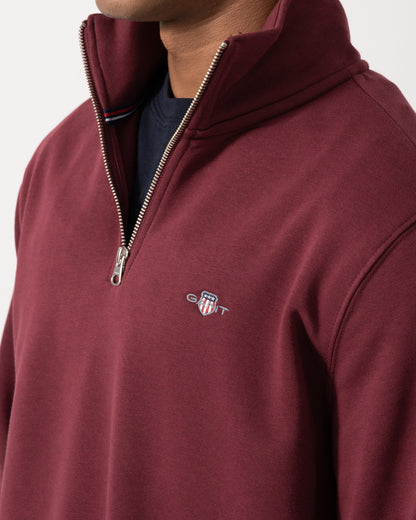 Close up of the GANT Mens Regular Fit Shield Logo Half Zip Sweatshirt - 676 Deep Grape Wine