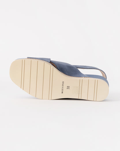 Blue sandal with a white sole on a light gray background