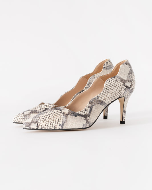 Pair of high-heeled shoes with snake print on a white background