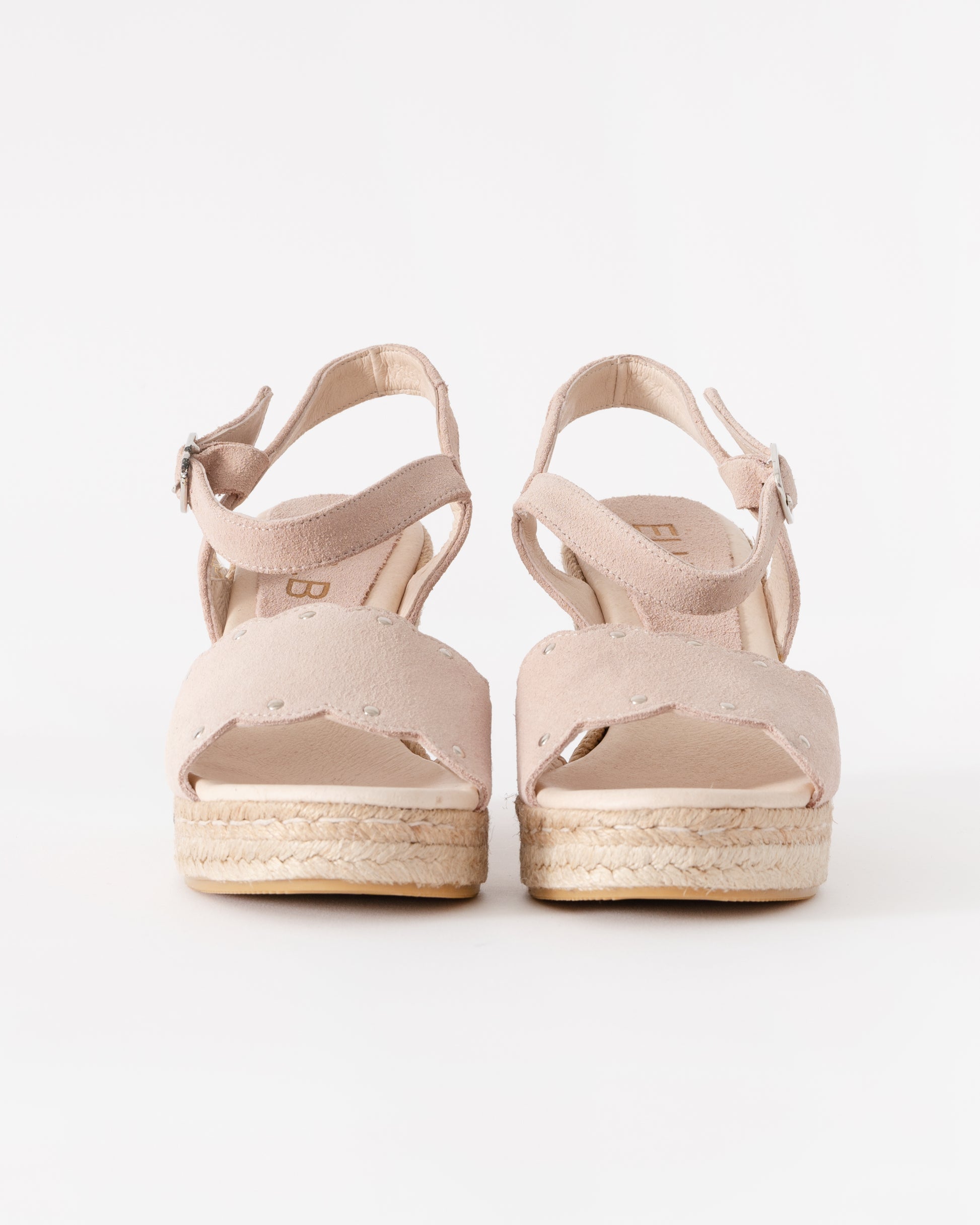 Pair of beige sandals with espadrille soles on a white background