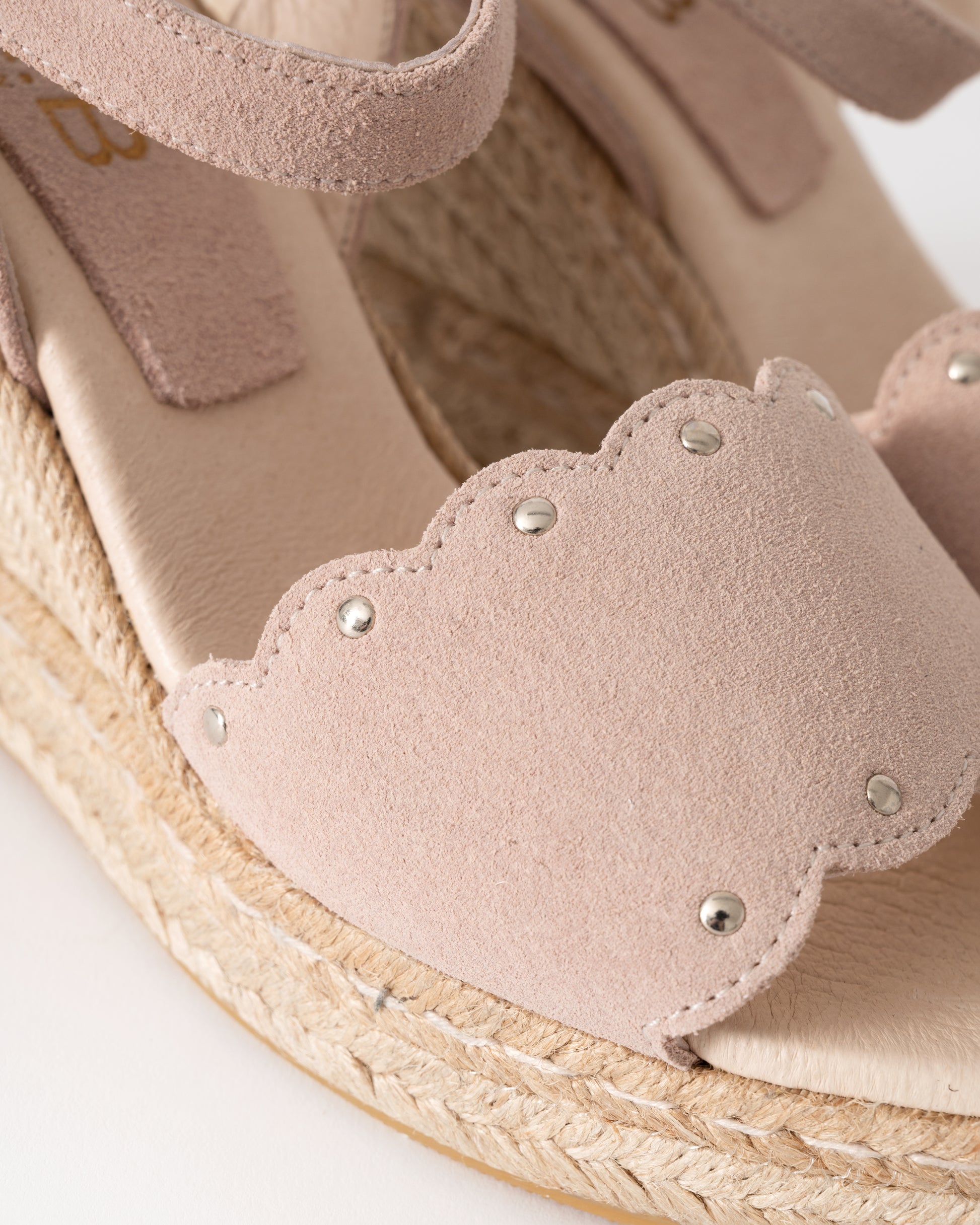 Close-up of a pink sandal with a textured sole on a white background
