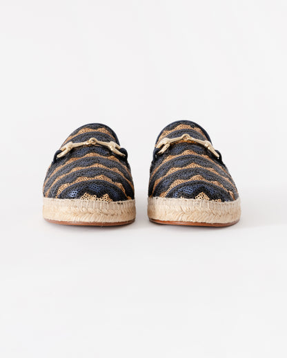 Pair of navy and gold espadrilles on a white background