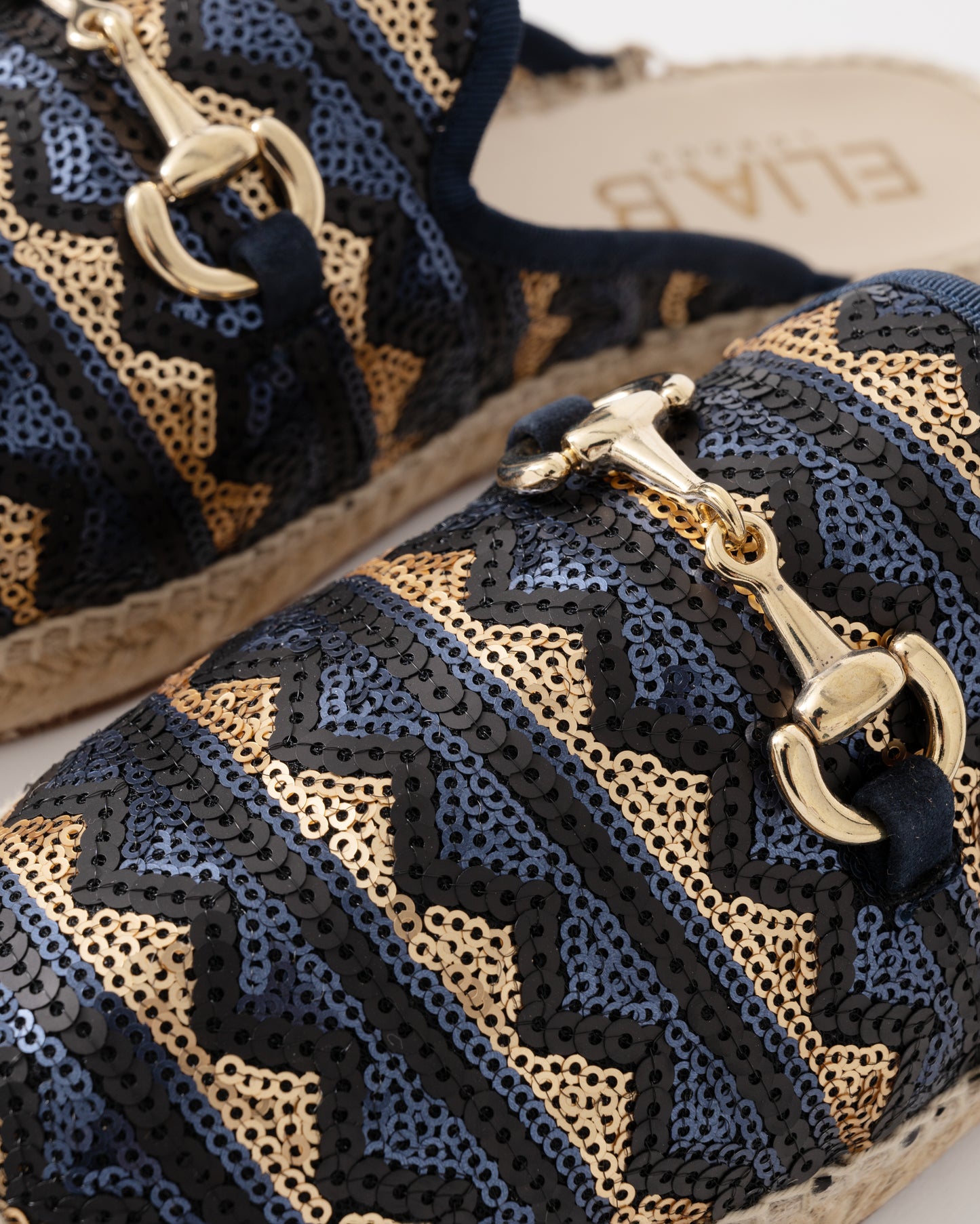 Black and gold patterned shoes with decorative elements on a white background