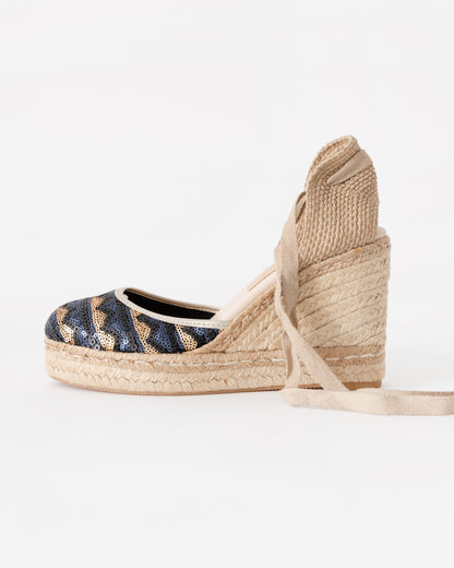 Woven wedge sandal with striped pattern on a white background