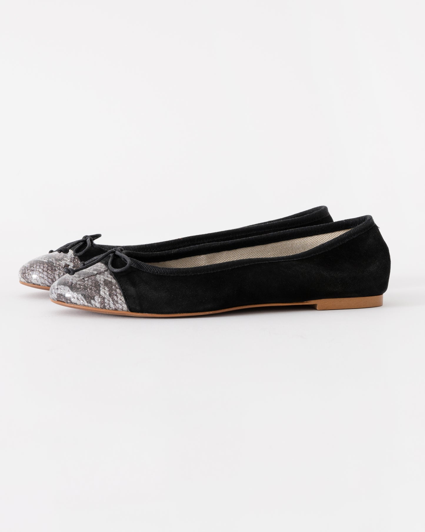 Black flats with glittery toe caps on a white background