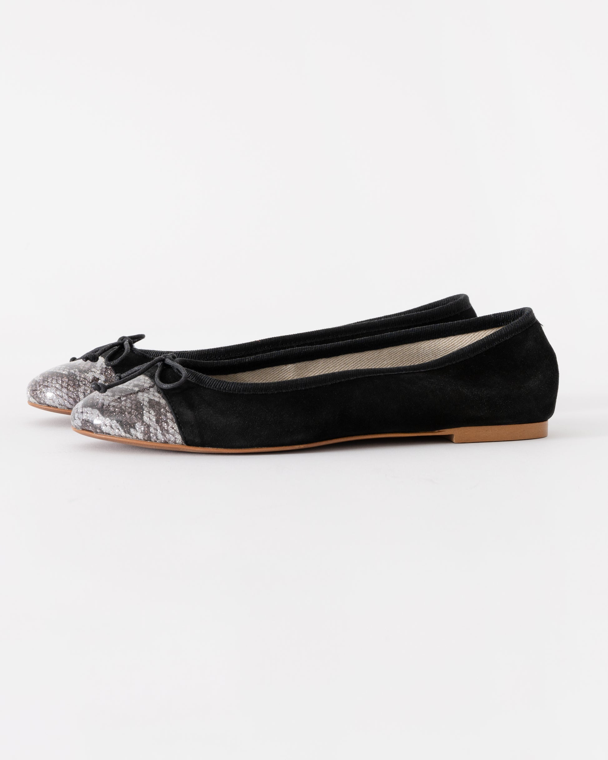 Black flats with glittery toe caps on a white background