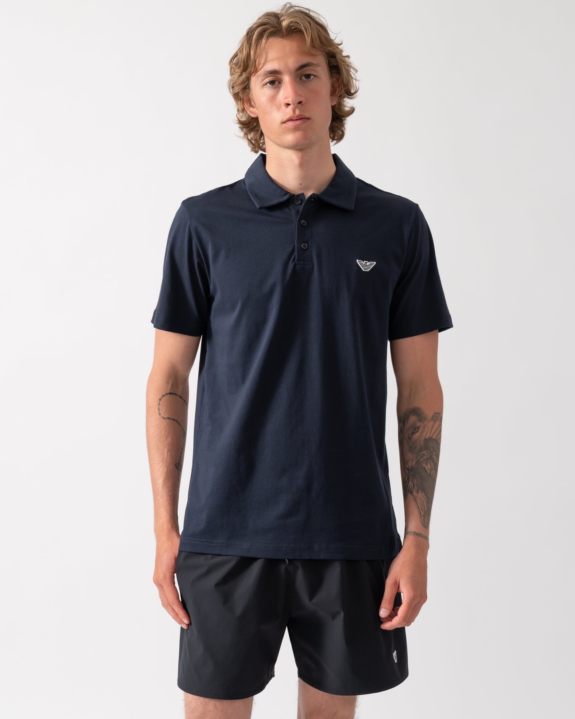 model wearing an Emporio Armani Mens Beach Polo with Eagle Logo in Armani Blue