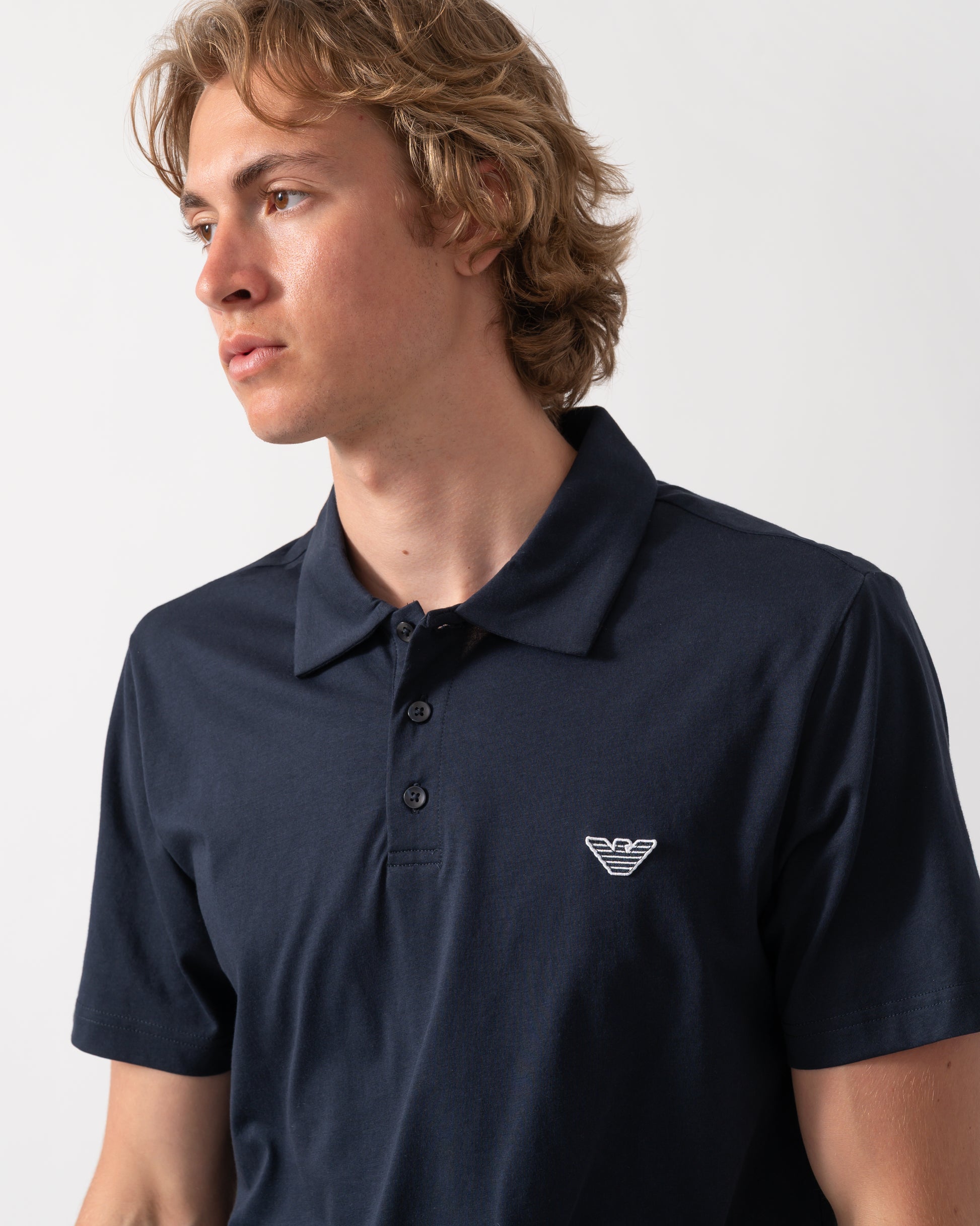 close up of model wearing an Emporio Armani Mens Beach Polo with Eagle Logo in Armani Blue