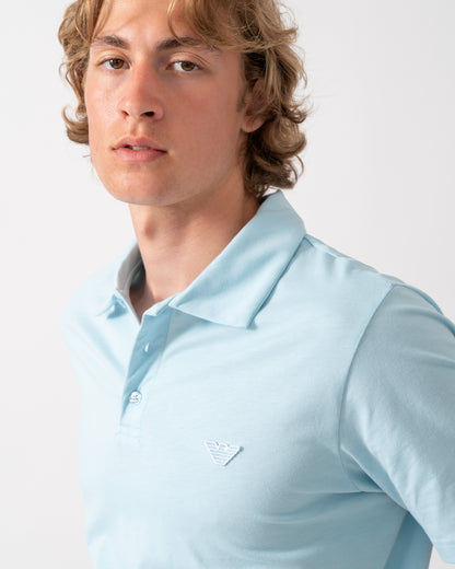 close up of a model wearing an Emporio Armani Mens Beach Polo with Eagle Logo in Sky blue