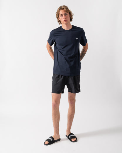 full length shot of a model wearing an Emporio Armani Mens Beach T-Shirt with Eagle Logo in Armani Blue