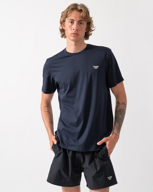 model wearing an Emporio Armani Mens Beach T-Shirt with Eagle Logo in Armani Blue