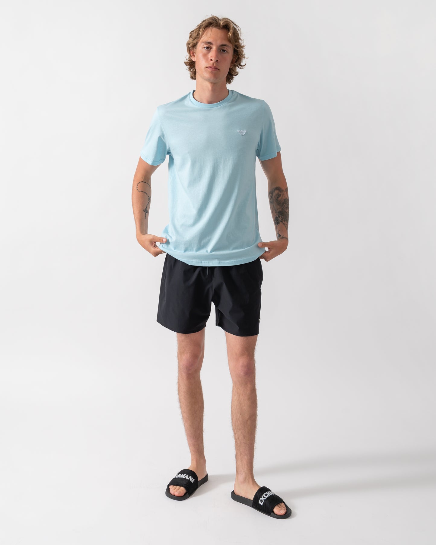 full length shot of a model wearing an Emporio Armani Mens Beach T-Shirt with Eagle Logo in Sky
