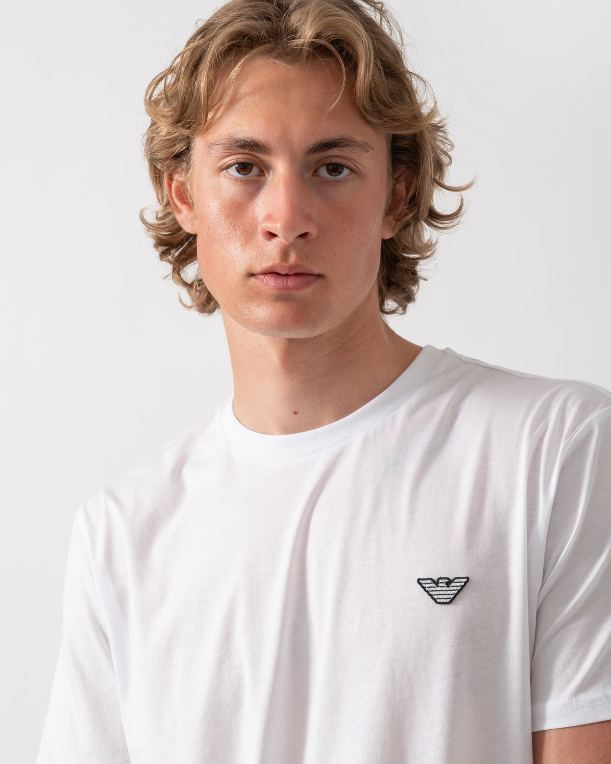 close up shot of a model wearing an Emporio Armani Mens Beach T-Shirt with Eagle Logo in White