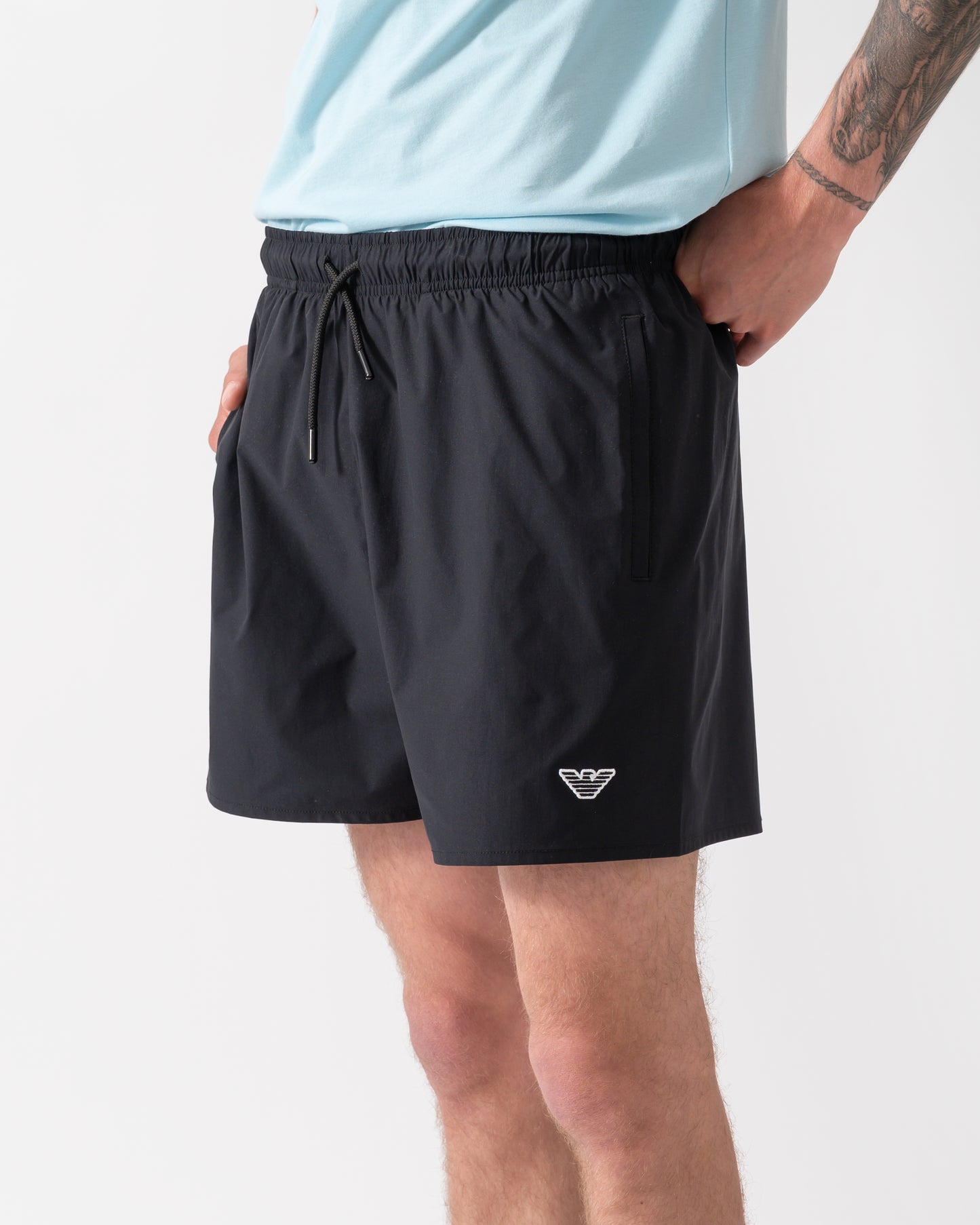 model wearing a pai of Emporio Armani Mens Swim Shorts with Eagle Logo in Black