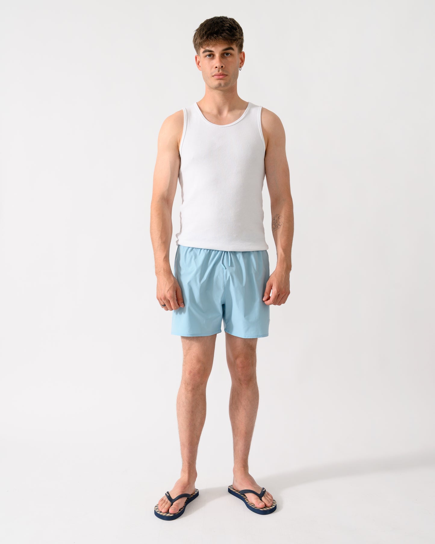 full length shot of a model wearing a pair of Emporio Armani Mens Swim Shorts with Eagle Logo in Sky