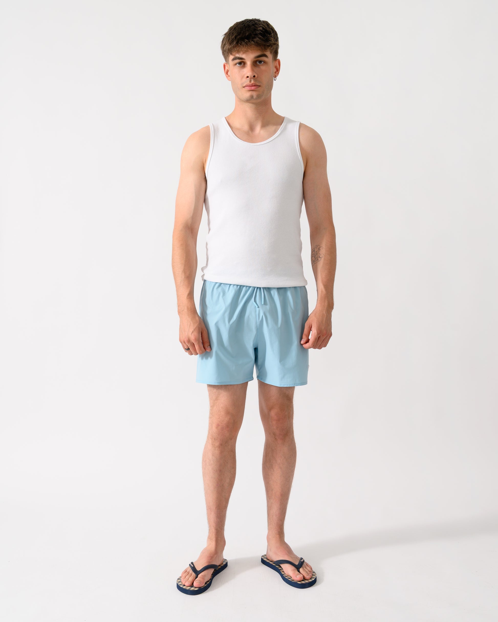 full length shot of a model wearing a pair of Emporio Armani Mens Swim Shorts with Eagle Logo in Sky