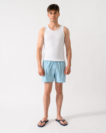 full length shot of a model wearing a pair of Emporio Armani Mens Swim Shorts with Eagle Logo in Sky