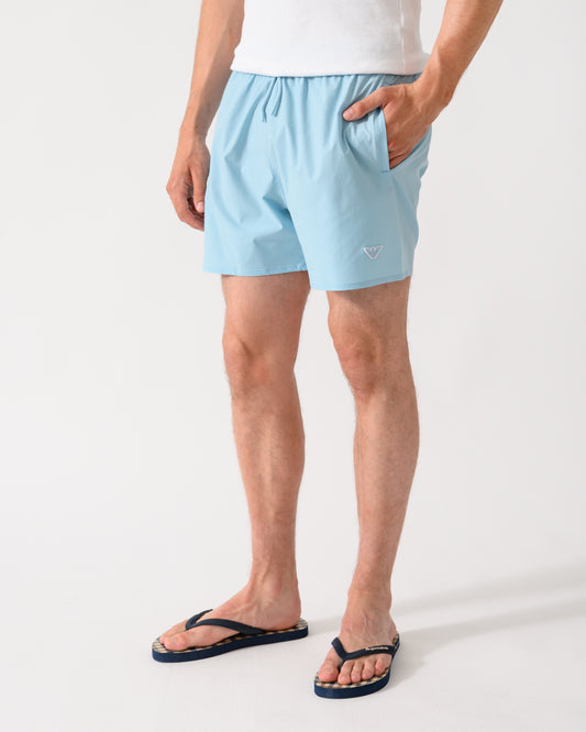 model wearing a pair of Emporio Armani Mens Swim Shorts with Eagle Logo in Sky