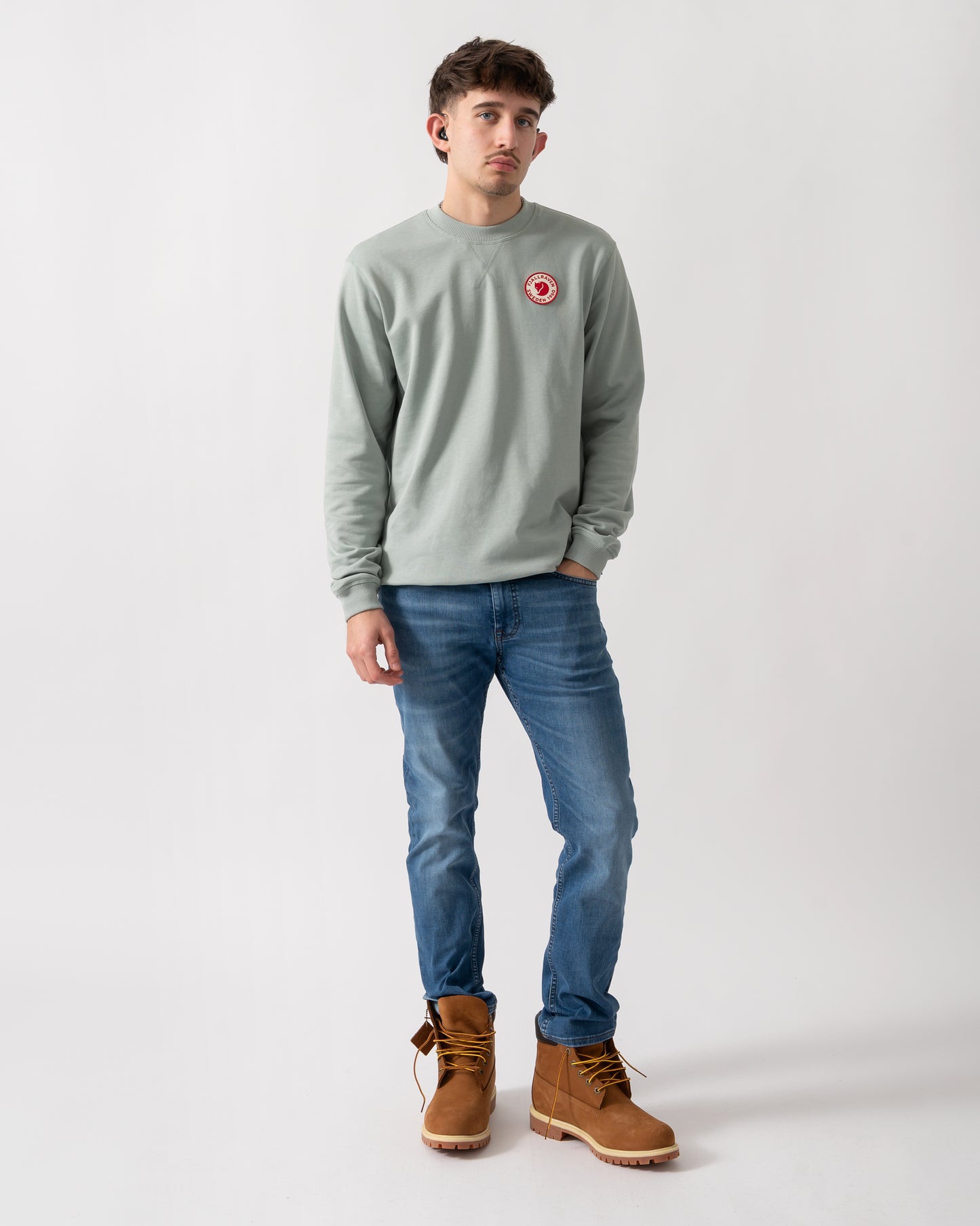 full length shot of a model wearing a Fjallraven 1960 Logo Badge Mens Sweatshirt in Misty Green 674