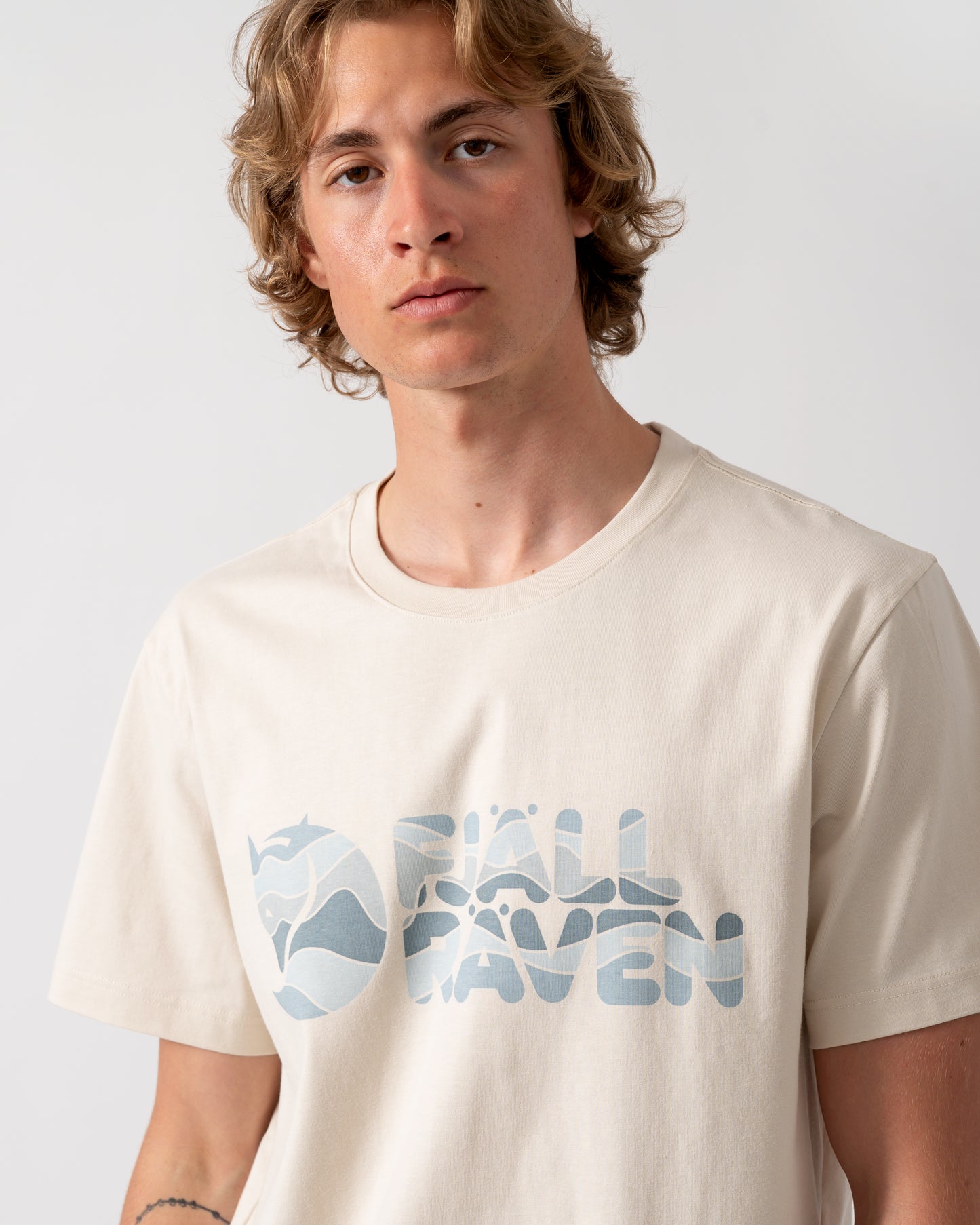 close up shot of a model wearing a Fjallraven Multicolor Logo Mens T-Shirt in Chalk White 113