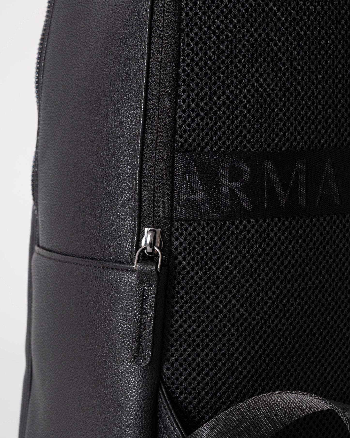 Close-up of a black backpack with a brand logo on a white background
