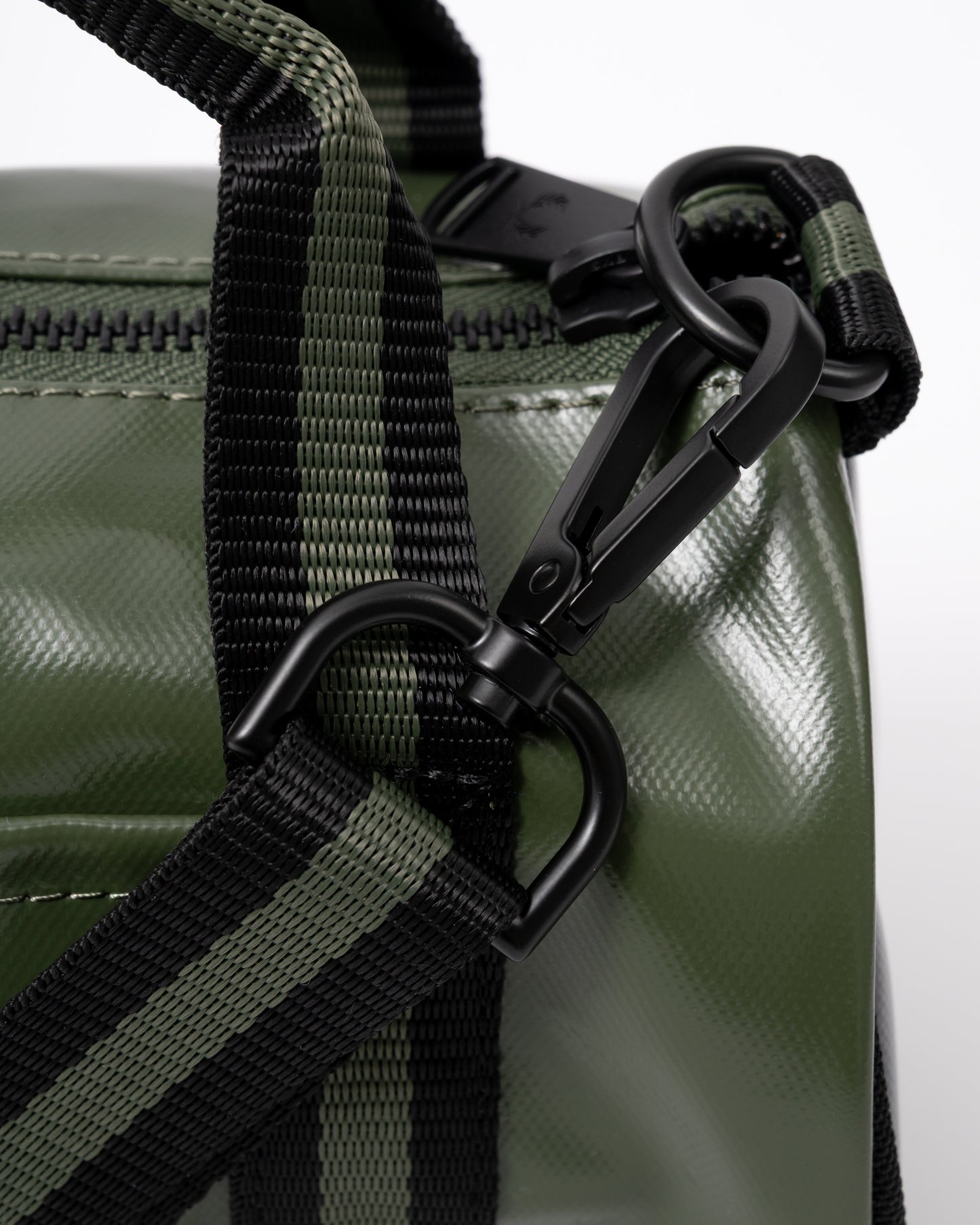 strap clip detail of a Fred Perry Classic Mini Barrel Bag in Laurel Wreath Green and Black Z50