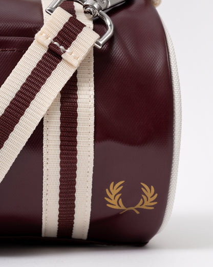 logo detail of a Fred Perry Classic Mini Barrel Bag in Oxblood and Ecru