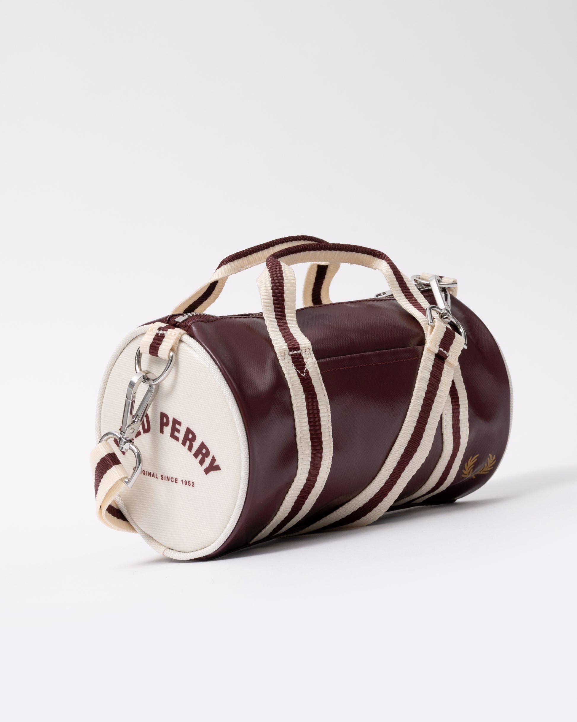 three quarter view of a Fred Perry Classic Mini Barrel Bag in Oxblood and Ecru