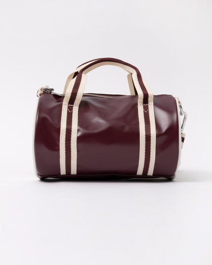 side view of a Fred Perry Classic Mini Barrel Bag in Oxblood and Ecru