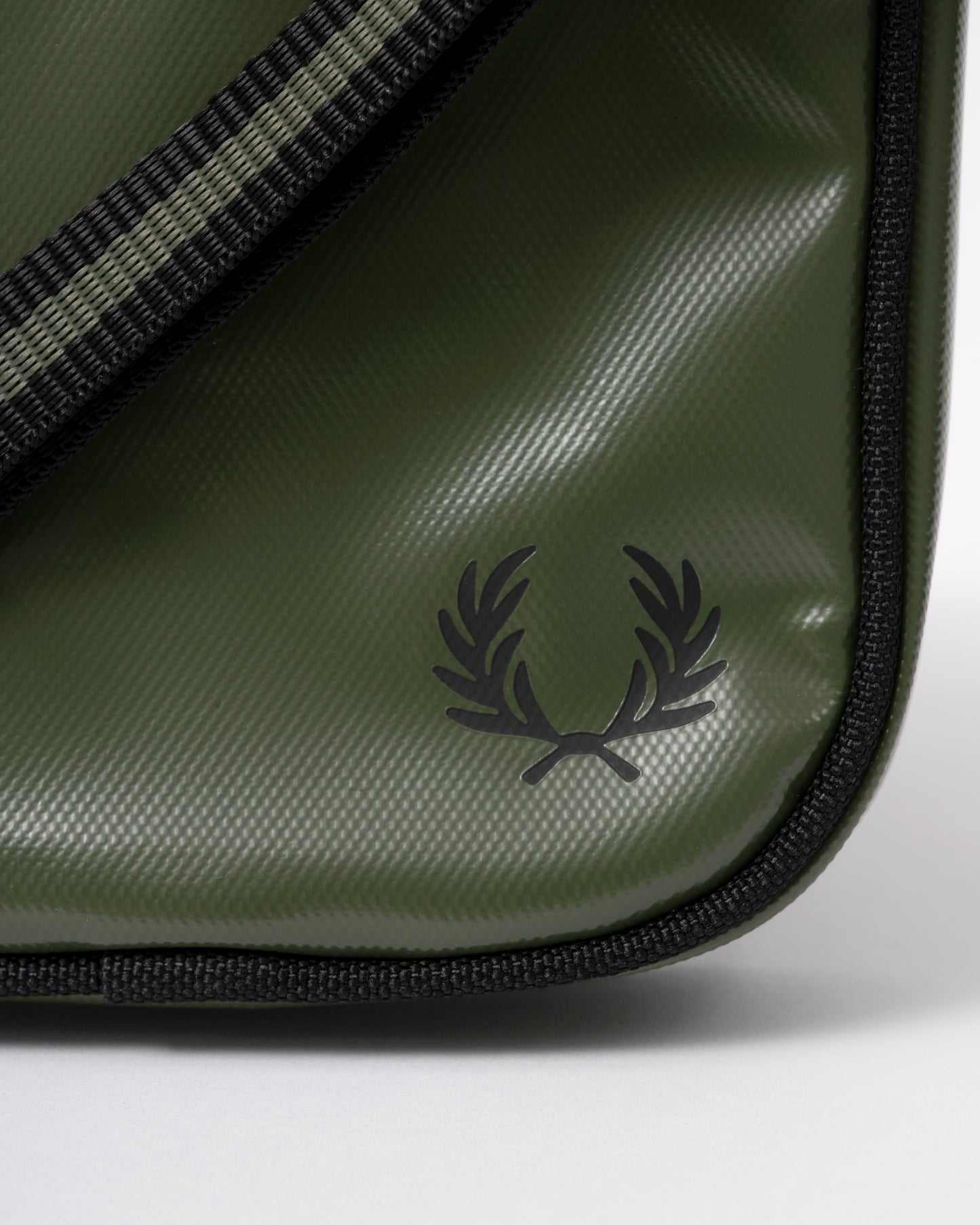 logo detail of a Fred Perry Classic Small Side Bag in Laurel Wreath Green and Black Z50