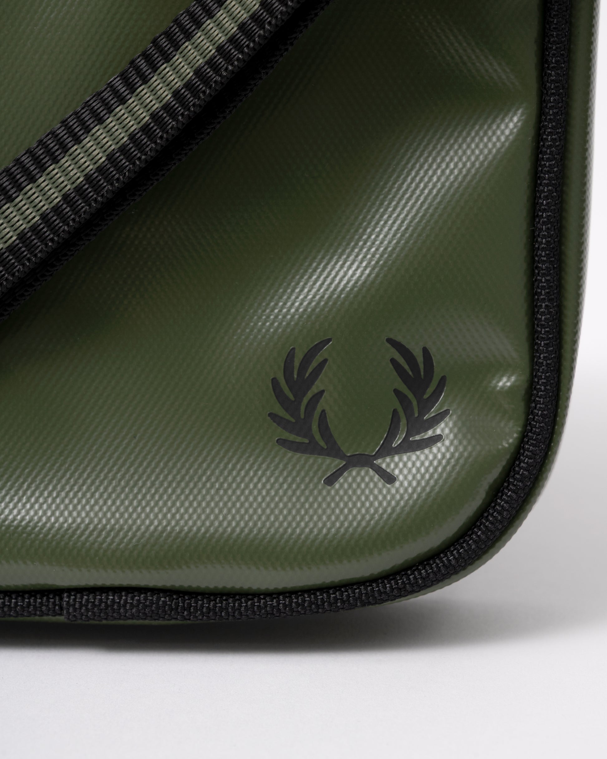 logo detail of a Fred Perry Classic Small Side Bag in Laurel Wreath Green and Black Z50