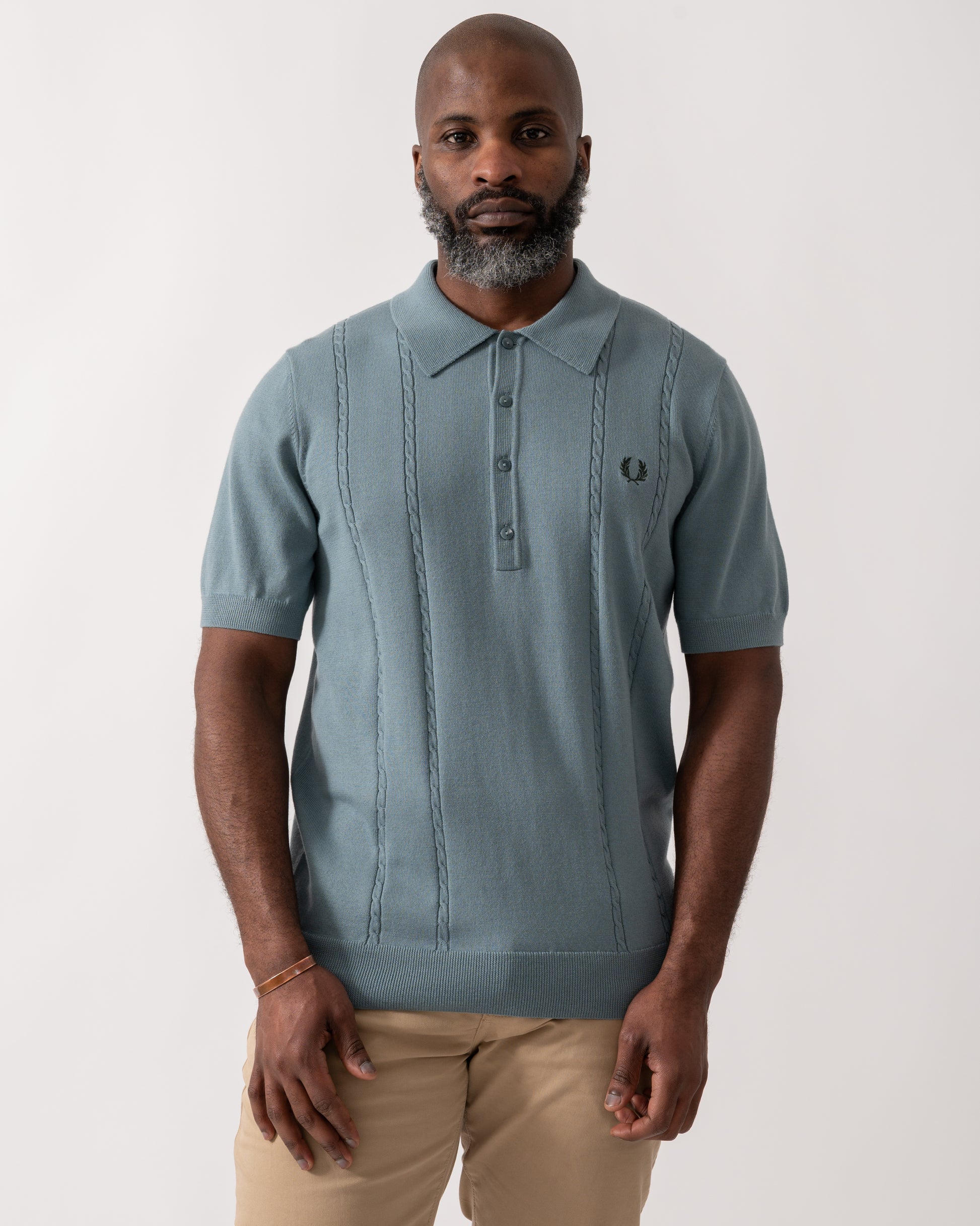 model wearing a Fred Perry Mens Cable Knitted Polo Shirt in Stockport Blue