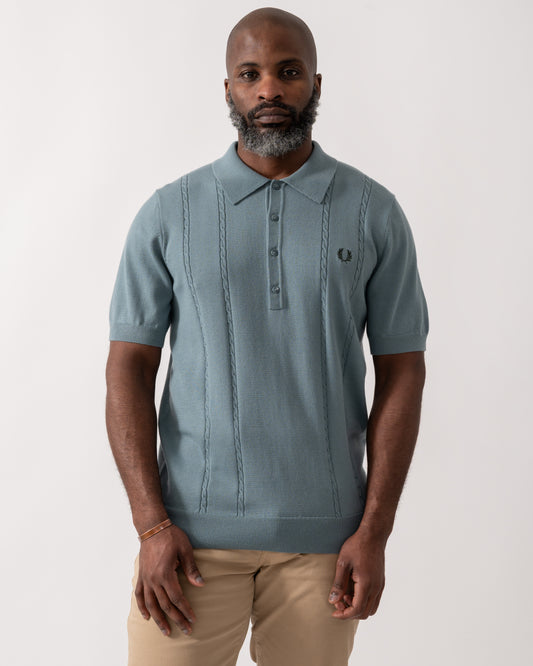 model wearing a Fred Perry Mens Cable Knitted Polo Shirt in Stockport Blue