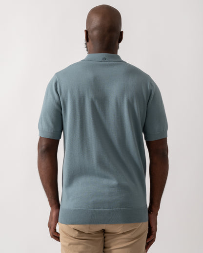 back shot of a model wearing a Fred Perry Mens Cable Knitted Polo Shirt in Stockport Blue