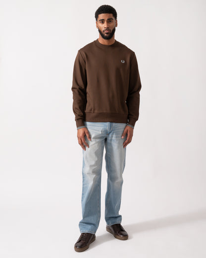 full length of a Model wearing a Fred Perry Mens Crew Neck Sweatshirt in Burnt Tobacco with Stockport Blue trim and logo
