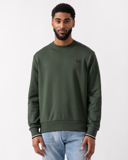model wearing a Fred Perry Mens Crew Neck Sweatshirt in Court Green, with Snow White trim and Navy logo